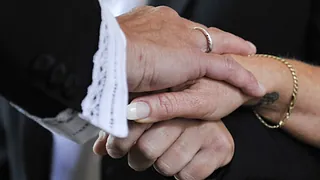 En præst lægger sin hånd over brudeparrets hænder